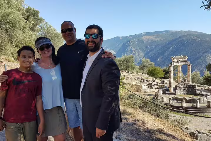 Tourists enjoy a guided private day trip from Athens to Delphi, exploring ancient ruins and stunning mountain views.