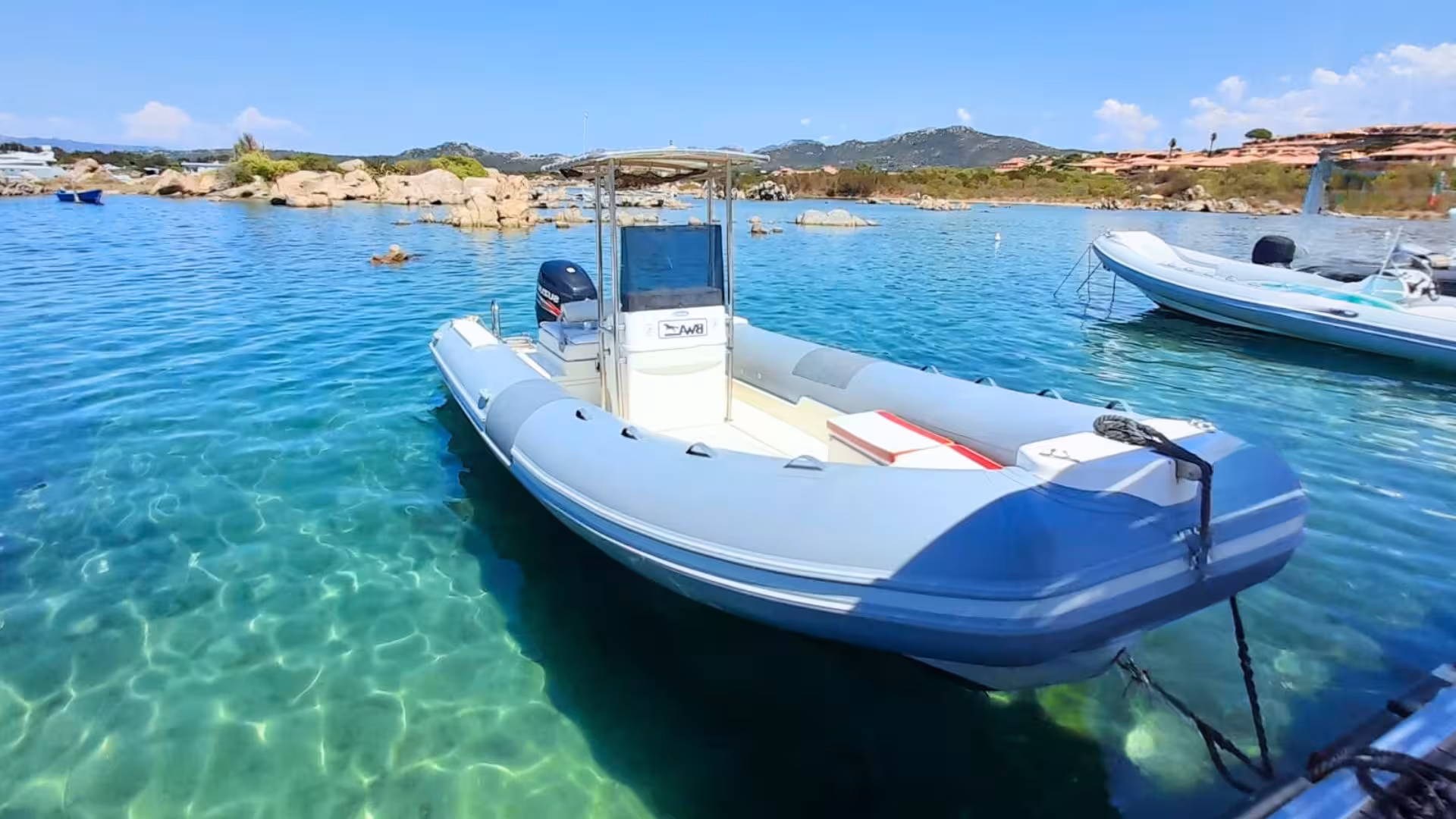 Close-up of a private dinghy tied in clear blue waters, ideal for exploring between Tavolara and Porto Cervo.