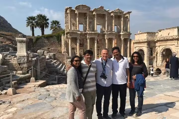 Tourists enjoying a skip-the-line private tour at the ancient ruins of Ephesus, with the Library of Celsus in view.