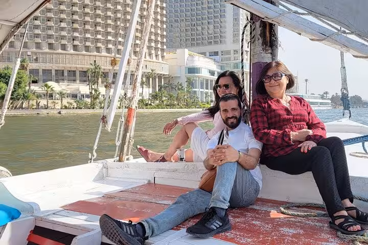 Family relaxing on a traditional felucca deck during a private Nile River sail in Cairo, Egypt