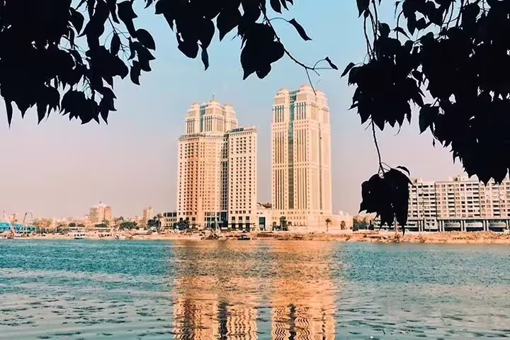 Cairo skyline and riverside towers reflected on the Nile, scenic view on a private felucca sailing tour