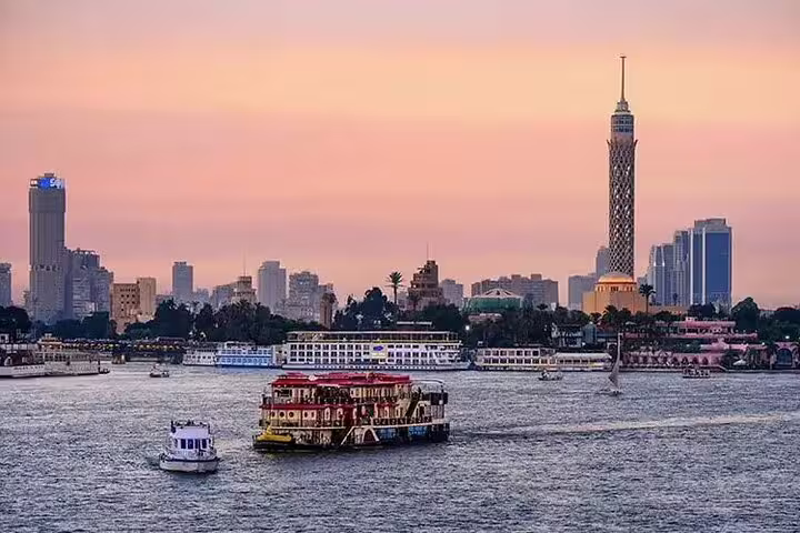 Cairo skyline at sunset from the Nile with boats and Cairo Tower, perfect for a private felucca ride
