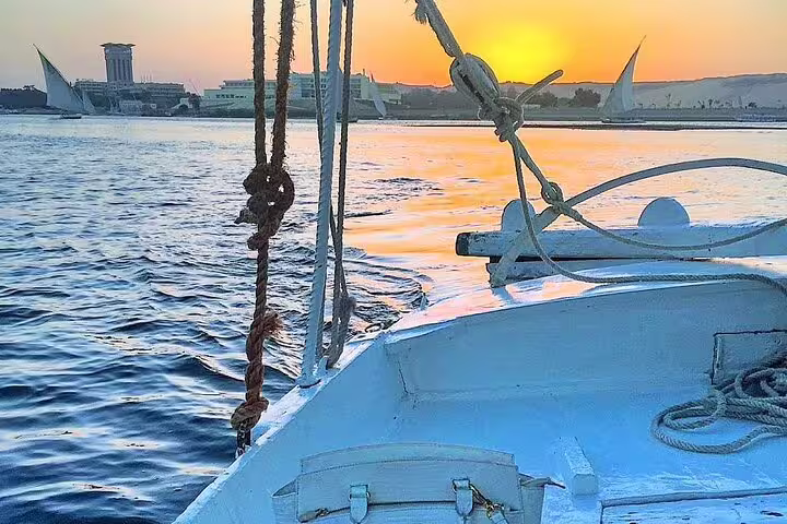 Sunset view from a private felucca sailboat on the Nile in Cairo, with calm waters and skyline ahead