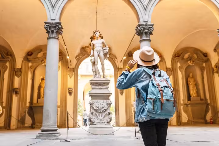 Tourist admiring a grand statue in a Renaissance-era gallery during a private Florence discovery tour.