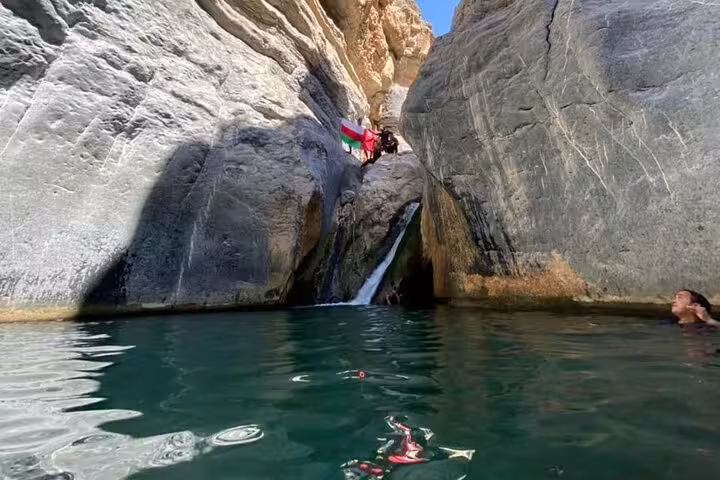 Explore the stunning rock formations and serene pools of Wadi Dham on a private full-day tour adventure.