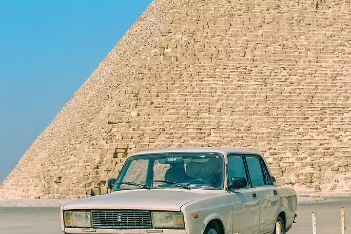 Private Giza Pyramids tour transfer car parked beside the Great Pyramid, Cairo day trip photo