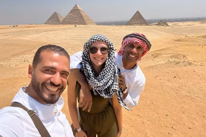 Happy travelers with local guide at Giza Pyramids on a private tour, desert views and photo stop
