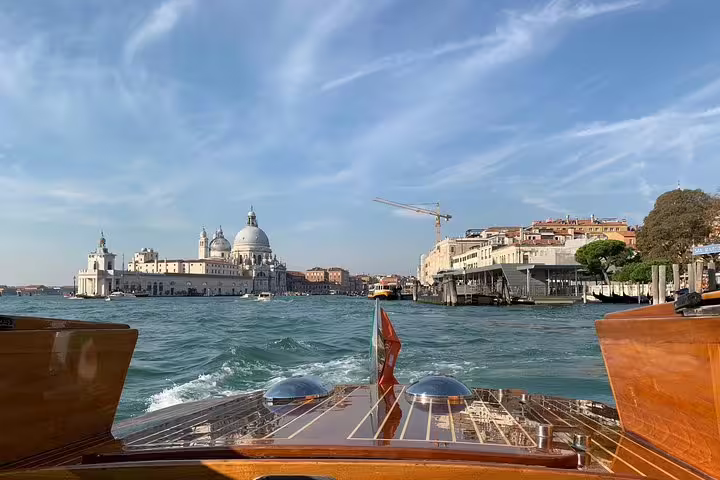 Stunning view from a private boat on the Grand Canal with Venice's iconic architecture and blue skies.