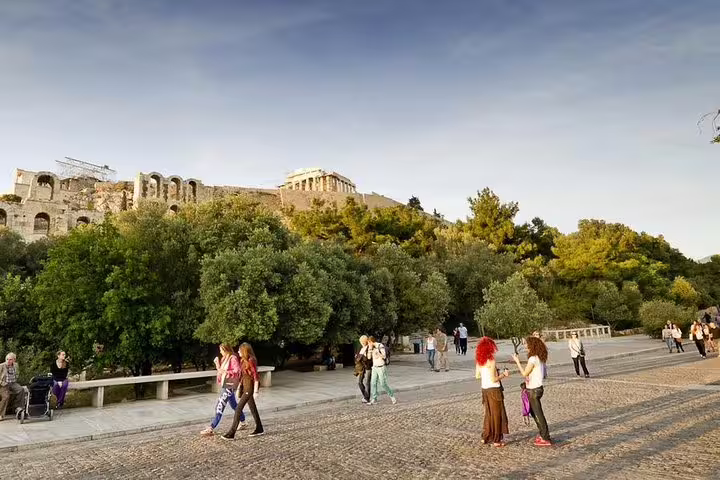 Travelers stroll near the Acropolis on a private half-day Athens sightseeing tour with scenic city views