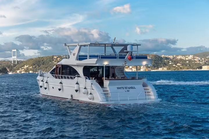 Private Istanbul Bosphorus yacht cruising past the shoreline with the Bosphorus Bridge in the background