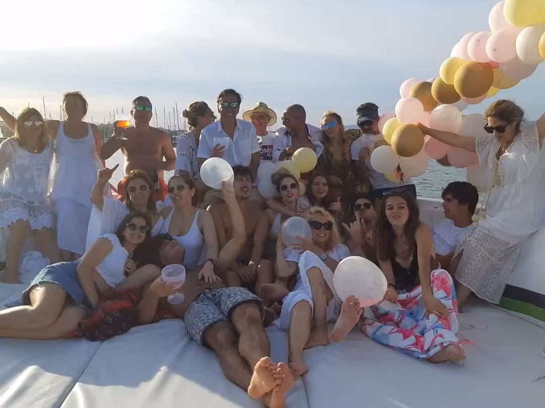 Group of friends celebrating on a private yacht with balloons at sunset, perfect for party-friendly private kayak tour add-ons