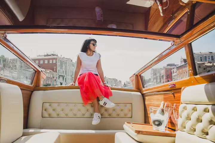 Woman enjoying scenic views from a luxurious limoboat during a private tour of Murano, Burano, and Torcello.