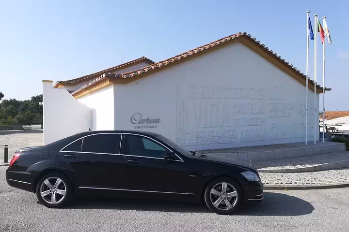 Private Lisbon Airport transfer sedan waiting outside building, reliable shuttle to Lisbon city center or return