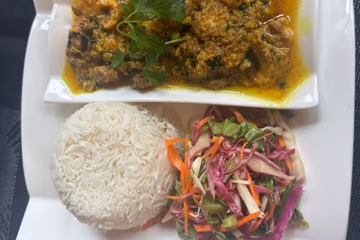 Savor authentic Creole cuisine with rice and fresh salad as part of a private Mahe island dining adventure.