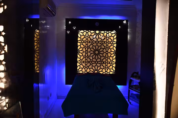 Private massage room in Sharm El Sheikh spa with blue ambient lighting and Moroccan-style wall panel