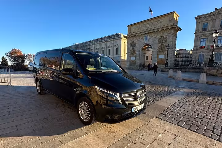 Private Mercedes van transfer from Avignon to Marseille Airport parked near city landmark, professional driver service