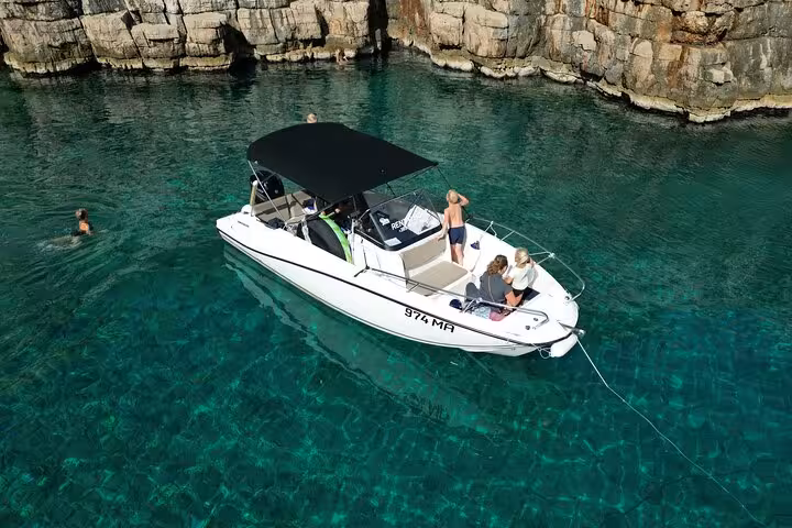 Private motorboat anchored in a turquoise Croatian cove for swimming and snorkeling on an Adriatic tour