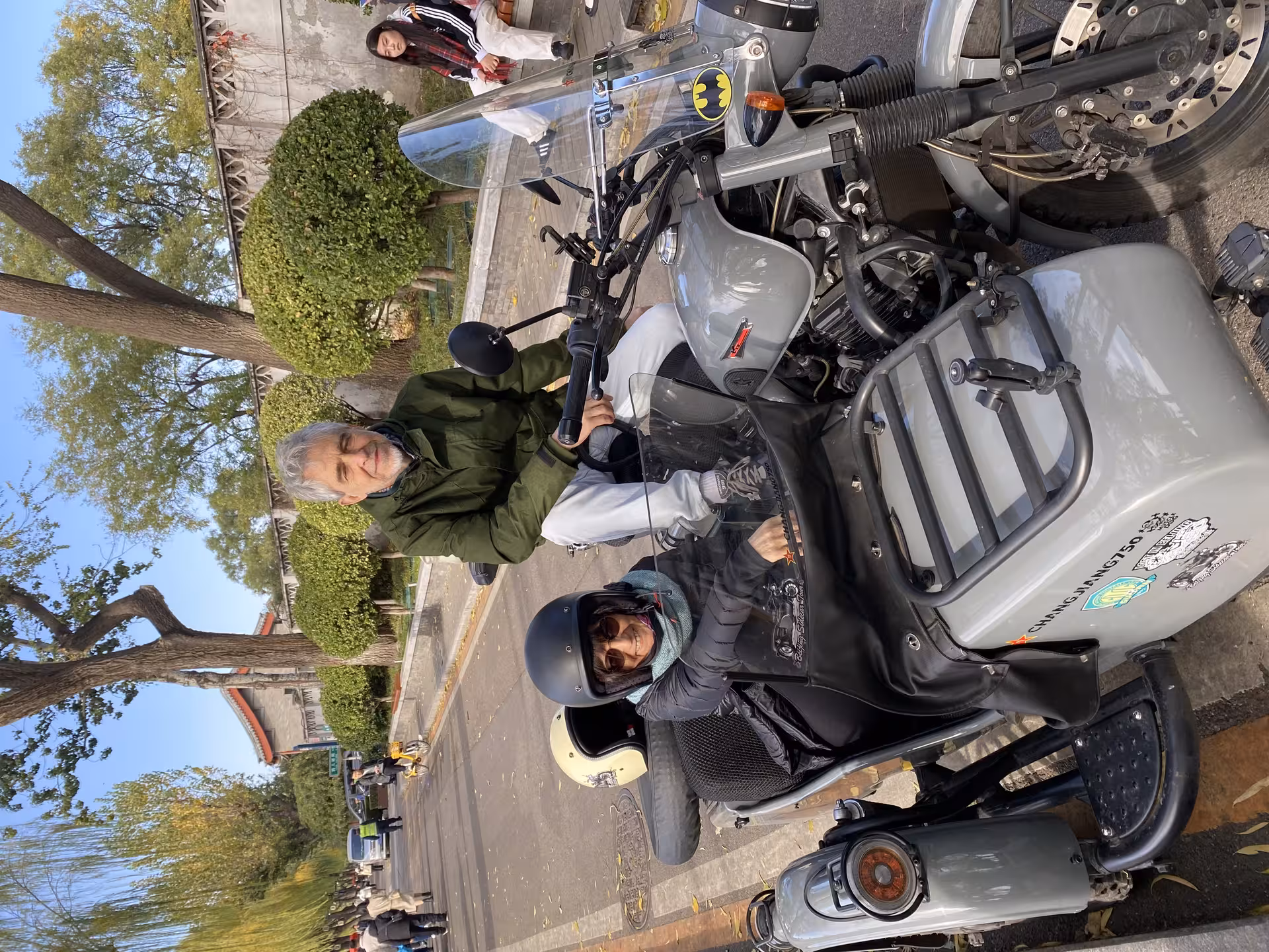 Tourists enjoying the Private Old Beijing City tour by sidecar, exploring historic streets and vibrant culture.