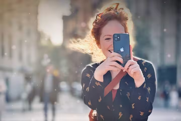 Woman capturing a lively street scene during a private phone photography class in the park and old town.