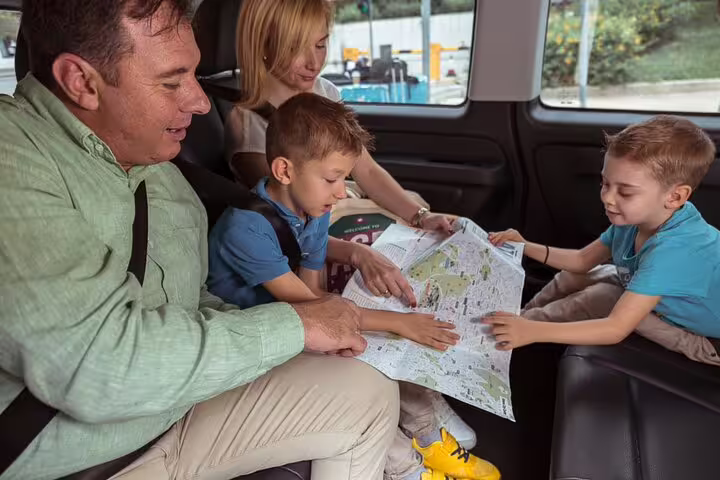 Family in private van planning route with map on Porto to Santiago de Compostela day trip, Spain excursion