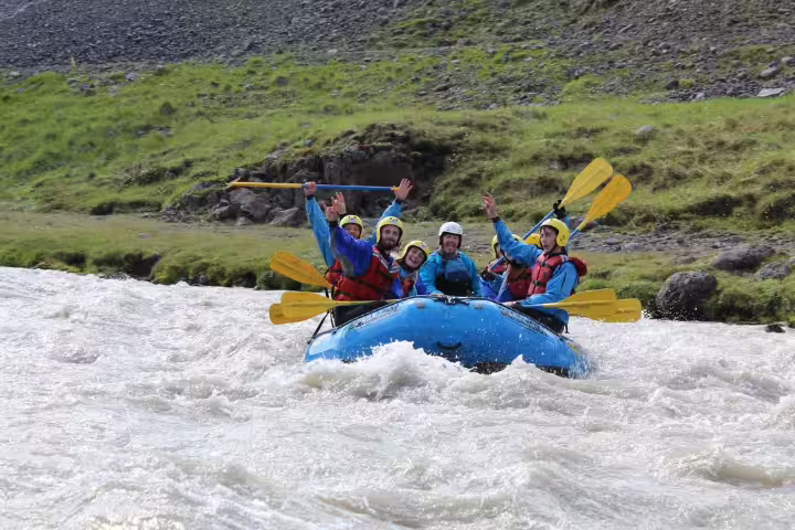 Group enjoying thrilling private rafting adventure on West Glacial River near Akureyri, surrounded by lush Icelandic landscapes.