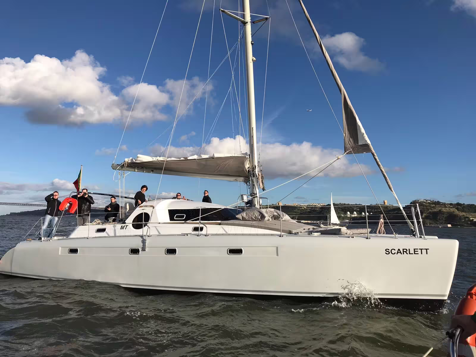 Experience a private sailing adventure on the catamaran 'Scarlett' with clear skies and serene waters.