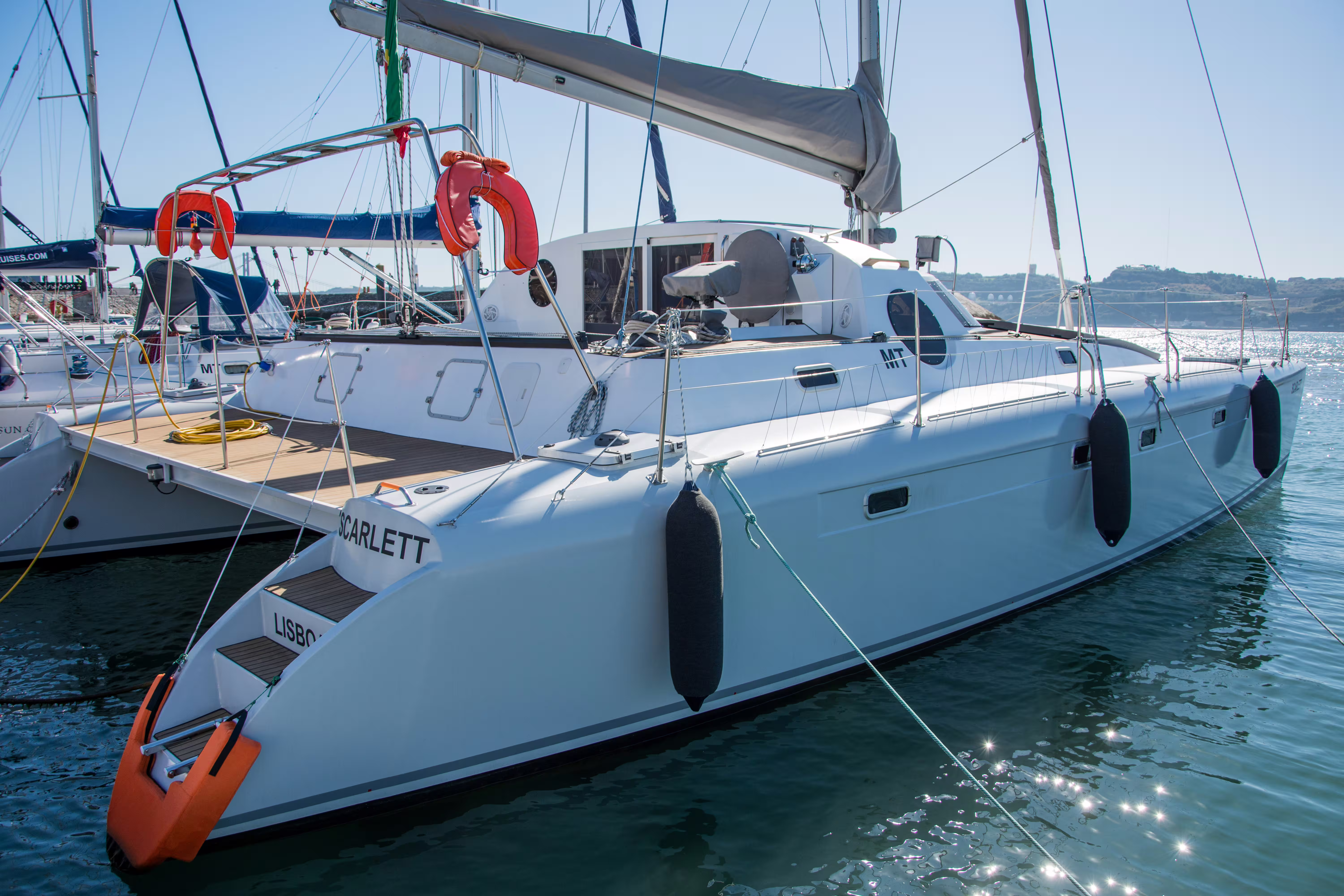 Explore the sleek design of the private sailing catamaran Scarlett, perfect for a 2-hour tour with up to 16 guests.