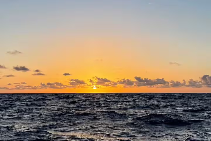 Breathtaking ocean sunset view from a full day private sailing cruise, showcasing serene waves and a vibrant sky.