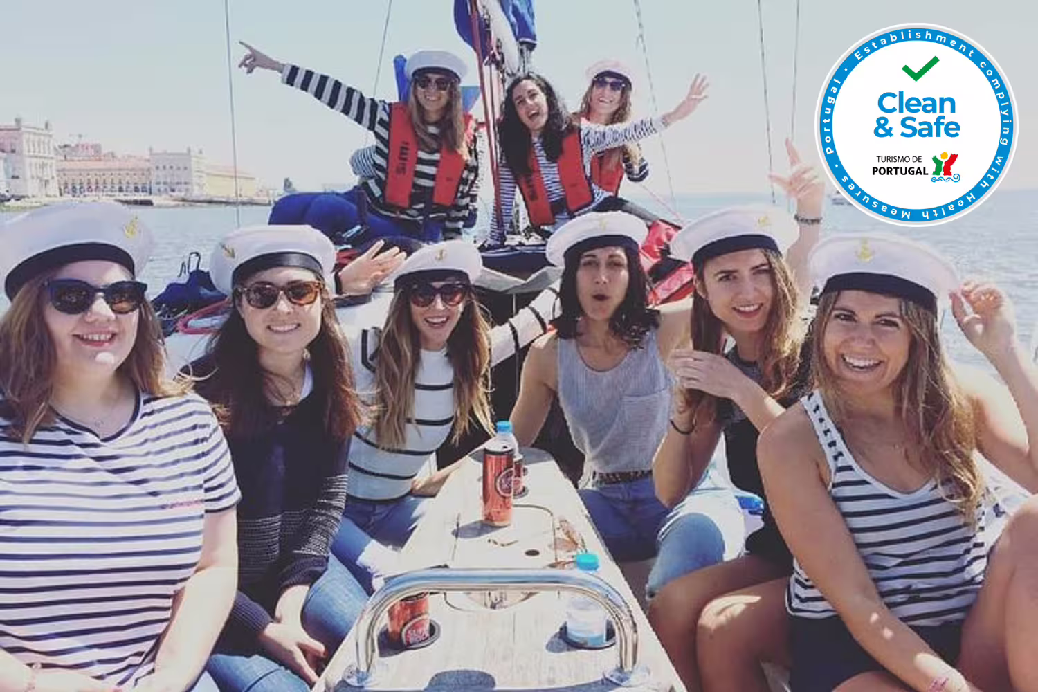 Happy friends wearing sailor hats on a private Lisbon sailing tour, showcasing a fun and safe maritime experience.