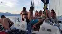 Friends relax and socialize on deck during a scenic private sailing tour in Rio de Janeiro.
