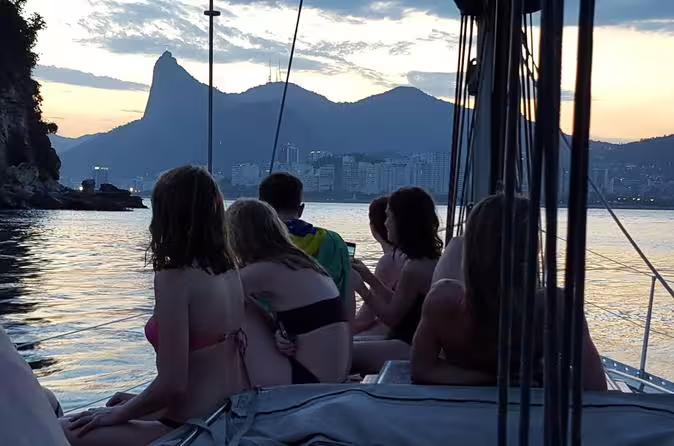 Group enjoying a sunset view from a private sailing tour near iconic Rio de Janeiro landmarks.