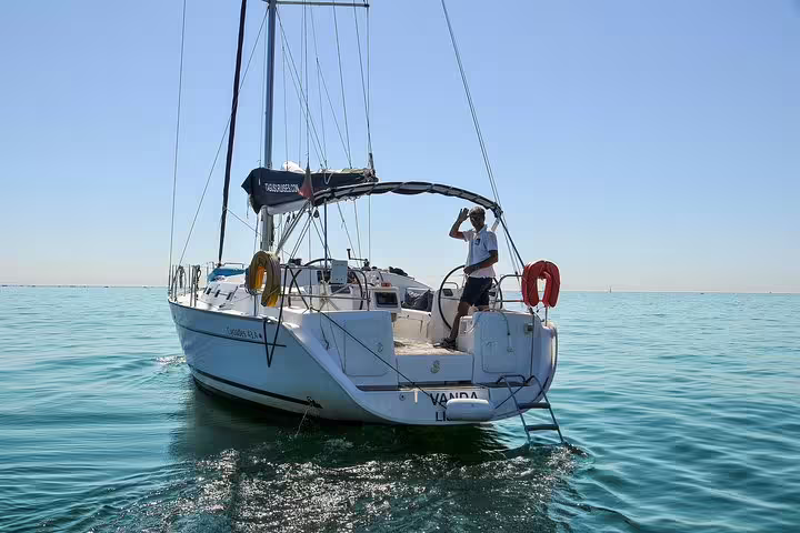 Sailboat on serene waters during a private 4-hour sailing trip to Oeiras beach under clear blue skies.
