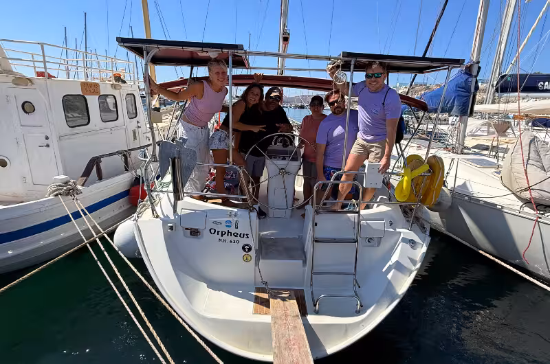 Group photo on a private Santorini sunset sailing catamaran at the marina, ready to depart for the caldera