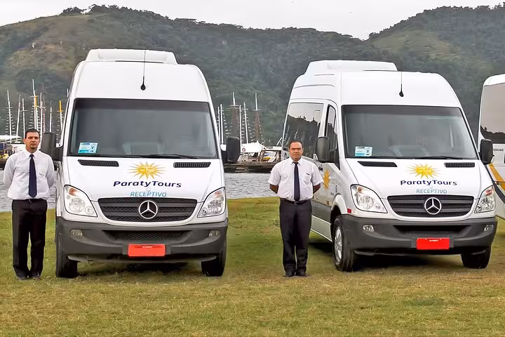 Two Paraty Tours shuttle vans with drivers, ready for private transport from Rio de Janeiro to Buzios, set against a scenic backdrop.