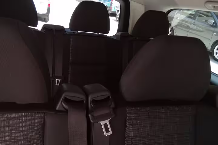 Clean spacious rear seats inside private shuttle van, comfortable airport welcome transfer with luggage space