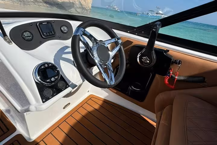 Private speedboat cockpit in Hurghada with steering wheel and gauges, heading to Hula Hula Island snorkeling