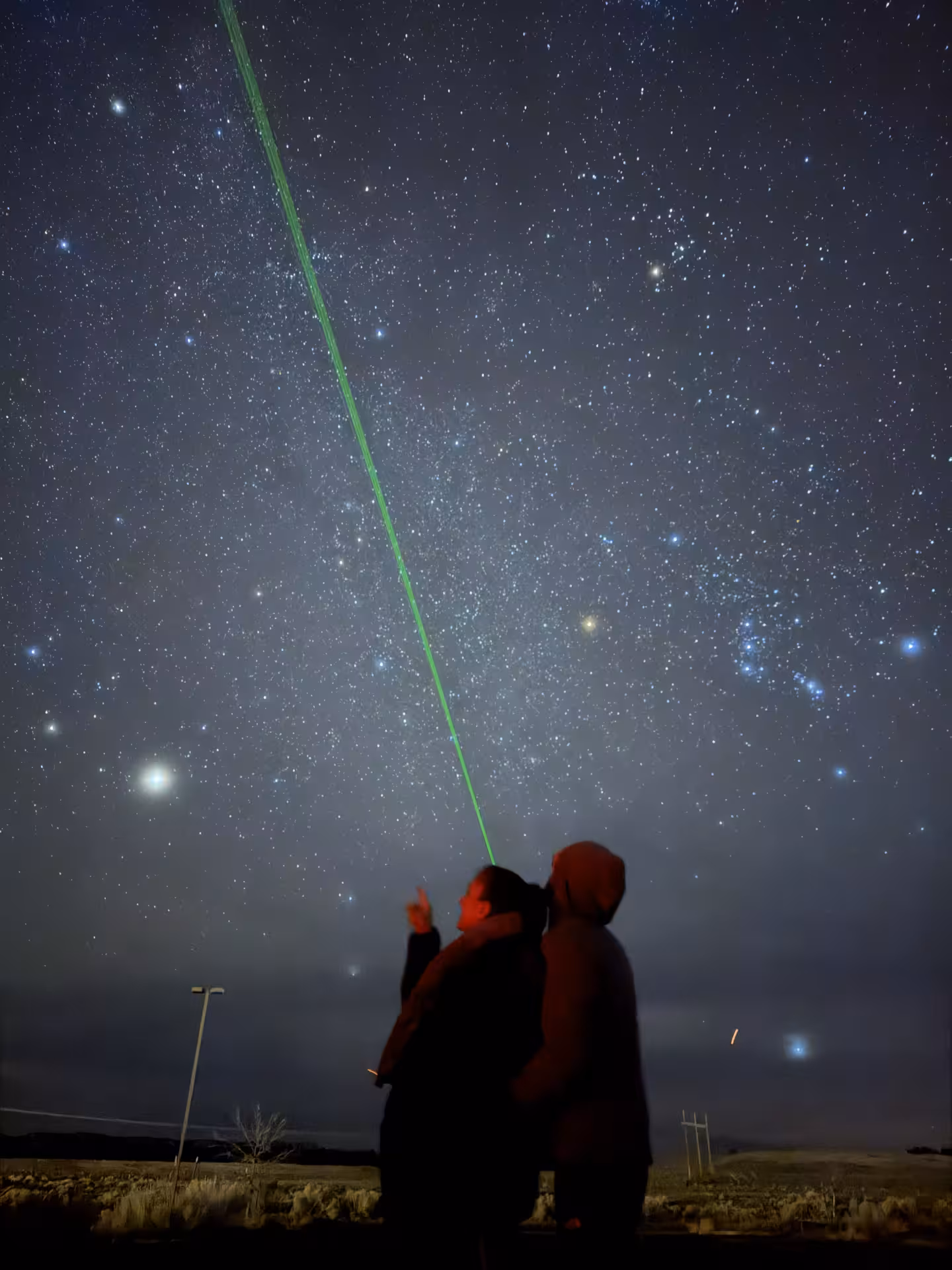Private stargazing experience with expert guide using green laser to point constellations in a dark sky