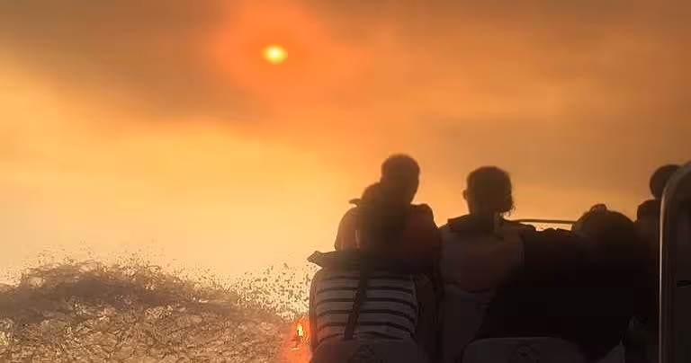 Guests enjoy a private sunset boat tour, speeding across golden waves as the sun sets over the tranquil sea horizon