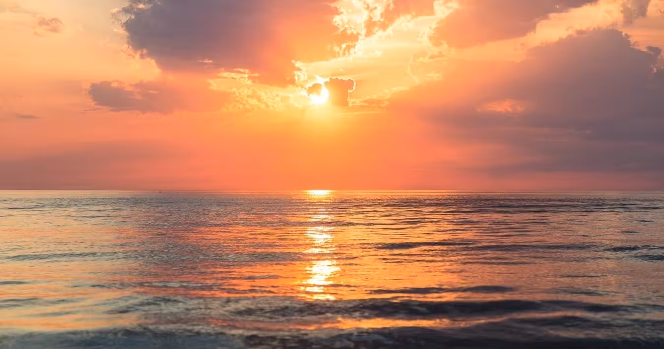 Golden sunset over tranquil sea, perfect backdrop for a romantic private sunset boat cruise experience