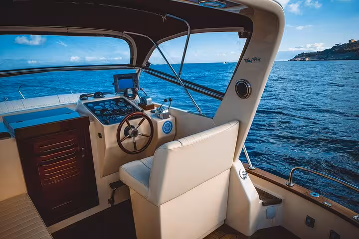 Luxurious boat cockpit on a private tour from Sorrento, offering panoramic ocean views under a clear blue sky.
