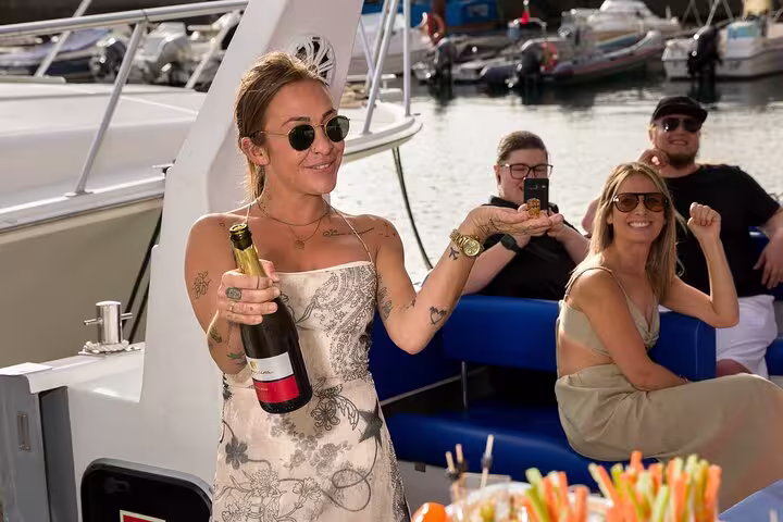 Guests celebrating with champagne on a luxurious private sunset cruise, capturing joyful moments onboard.