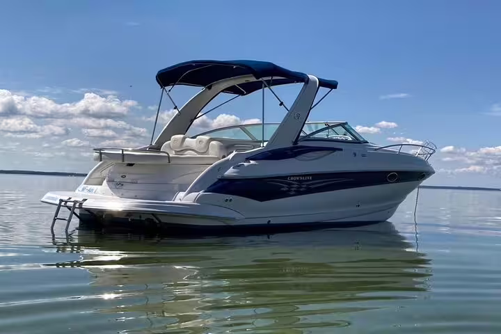 Motorboat anchored on calm waters under a clear blue sky, perfect for a private sunset tour around Milos Island.