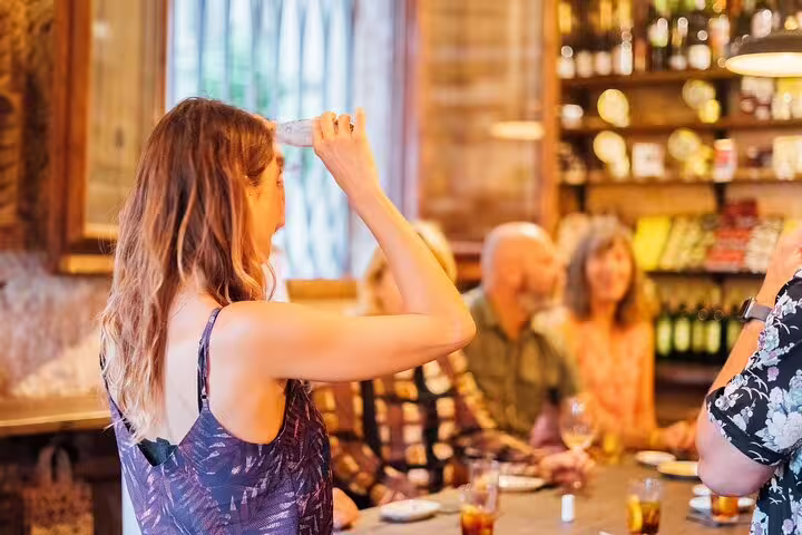 Guests enjoying wine and tapas in a charming, rustic setting during a private walking tour in Spain.