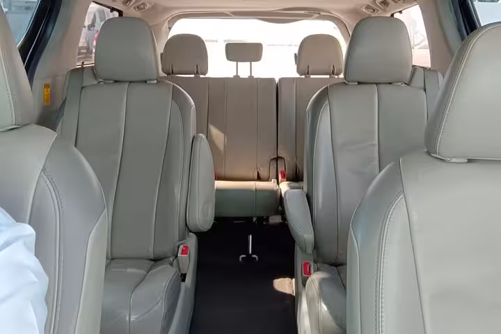 Spacious leather interior of private taxi minivan for Shangri-La to Muscat Airport transfer, ideal for small groups and families