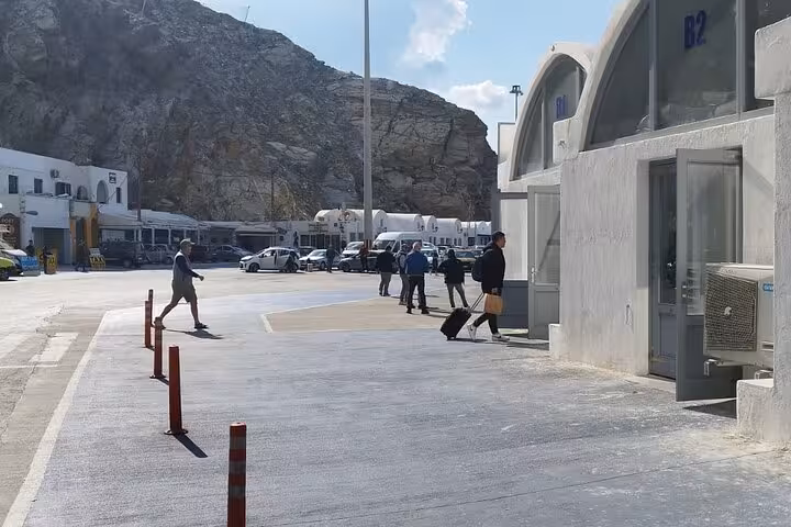 Passengers with luggage at ferry terminal curb, ideal for private chauffeur transfer and port pickup service