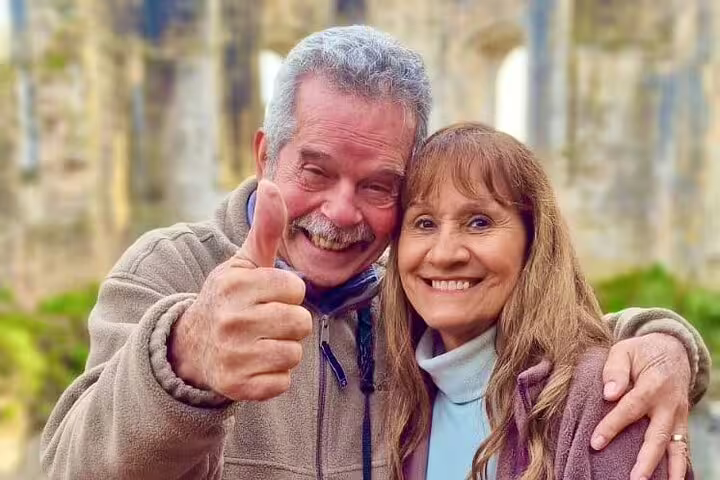 Smiling couple enjoying a private full-day tour from Lisbon to Tomar and Coimbra, capturing the joy of Portuguese heritage exploration.