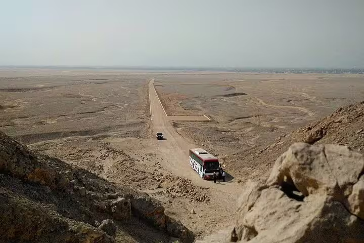 Tour bus on desert road near Tel El Amarna, scenic drive on private 2-day El Minya tour from Cairo