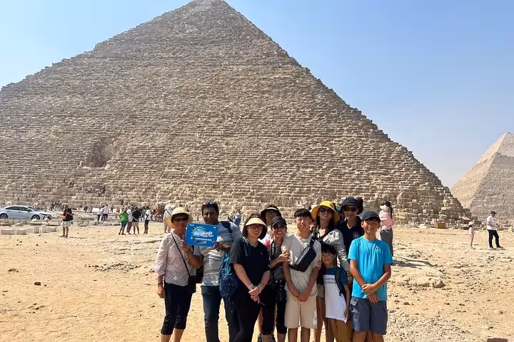 Private tour guests with guide in front of the Great Pyramid of Giza during full-day Cairo pyramids trip
