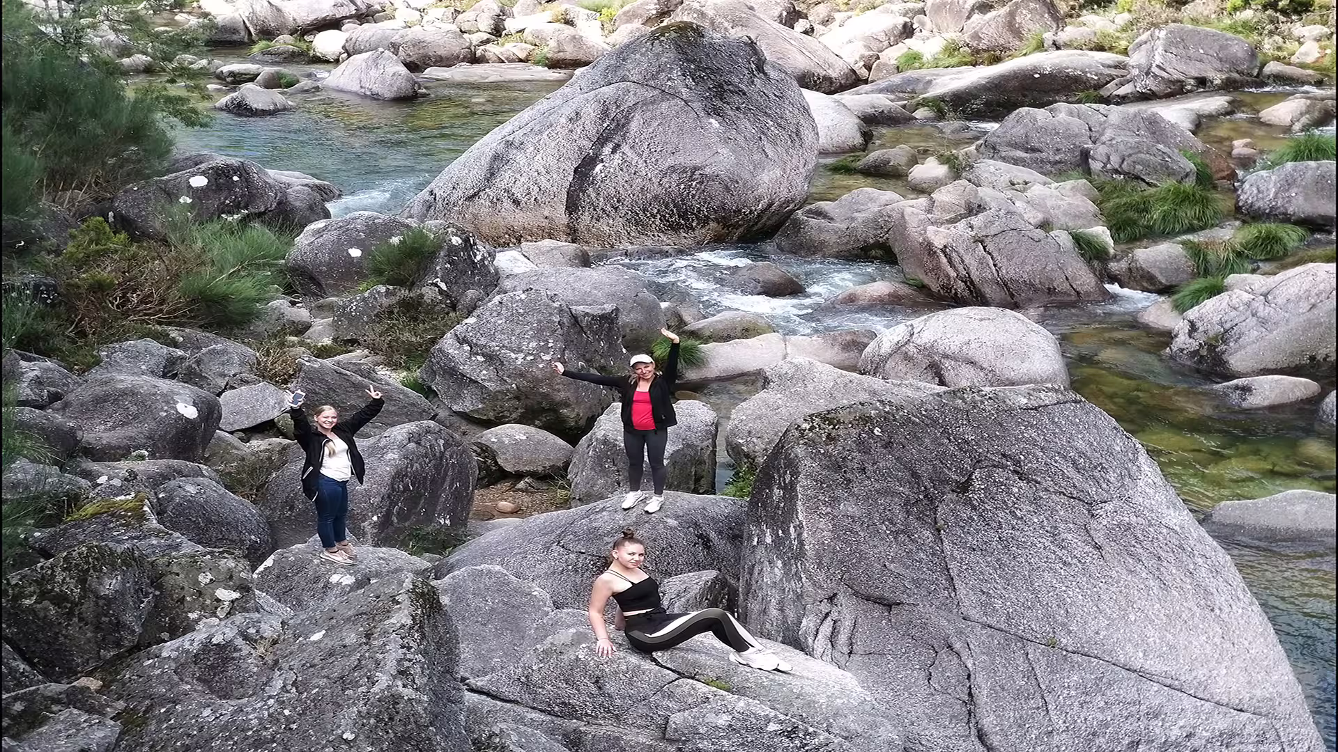 Adventurers exploring rocky terrain by a clear stream in Peneda-Gerês National Park on a private nature tour.