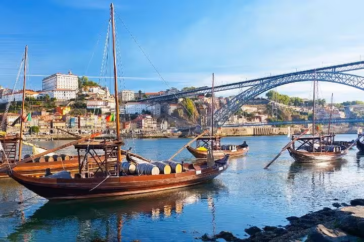 Traditional Rabelo boats on Douro River in Porto, ideal for a private tour, offering scenic views and cultural insights.